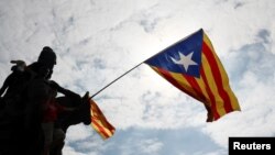 An Estelada (Catalan separatist flag) waves overhead during a protest one day after the banned independence referendum in Barcelona, Spain, Oct. 2, 2017. 