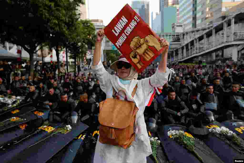 Seorang peserta unjuk rasa mengacungkan poster dalam aksi massa usai pengumuman hasil pilpres, di depan gedung Badan Pengawas Pemilihan Umum, Jakarta, Selasa, 21 Mei 2019. (Foto:Reuters) 