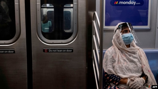 Một hành khách mang khẩu trang trên xe điện ngầm tại Thành phố New York.