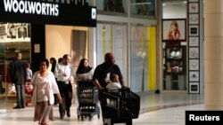 Shoppers leave a Woolworths store at a shopping centre in Lenasia, south of Johannesburg, Aug. 28, 2013. 