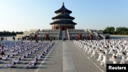 FILE - Indian Prime Minister Narendra Modi and Chinese Premier Li Keqiang, both center, attend a taiji and yoga event at the Temple of Heaven park in Beijing, China, May 15, 2015. 