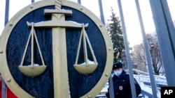 FILE - A police officer guards an entrance of a court, in Moscow, Russia, Dec. 29, 2021. Sergei Mingazov, a Forbes Russia journalist, has been detained in Russia over social media posts he made about Ukraine.