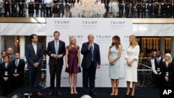 FILE - Then-candidate Donald Trump, accompanied by his family, speaks during the grand opening of the Trump International Hotel-Old Post Office, Washington, Oct. 26, 2016. 