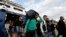 A man carries his belongings as other migrants and refugees arrive on a ferry from the Greek island of Lesbos at the Athens' port of Piraeus, Sept. 30, 2015. 