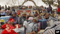 Bangladeshi migrant workers rest while they wait to return home at a refugees camp near the Libyan and Tunisian border crossing of Ras Jdir after fleeing unrest in Libya, March 5, 2011