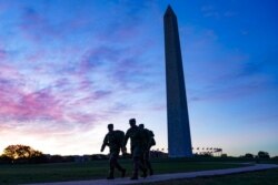 FILE - U.S. National Guard members walk toward the White House from the Washington Monument in Washington, Nov. 3, 2020.