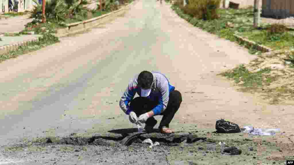 Un Syrien recueille des preuves sur le lieu de l&#39;attaque chimique à Khan Sheikhun, le 5 avril 2017.