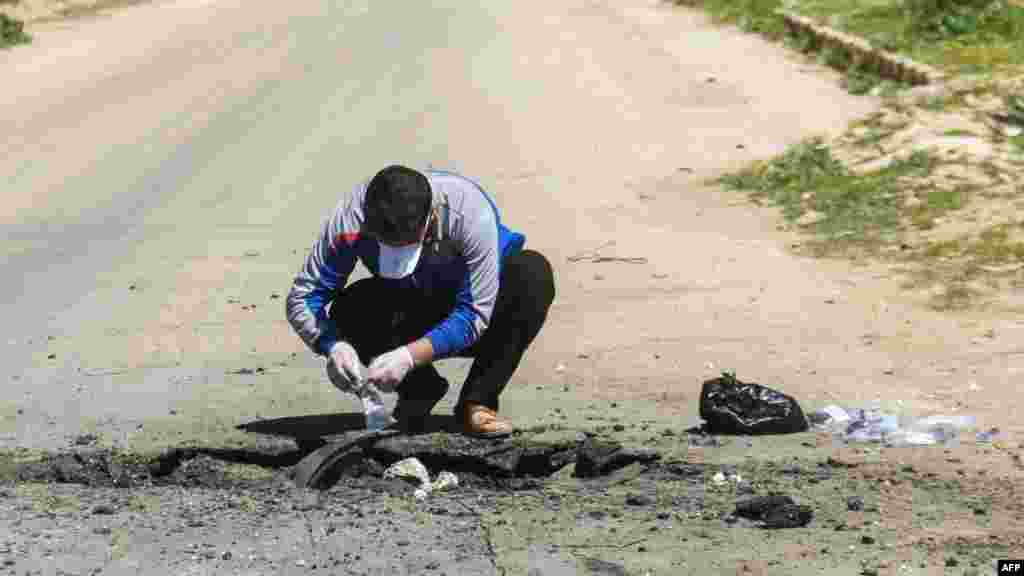 Un hombre sirio recoge muestras del sitio donde se cree se realizó el ataque en Khan Sheikhun, en la provincia de Idlib, Siria el 4 de abril de 2017.