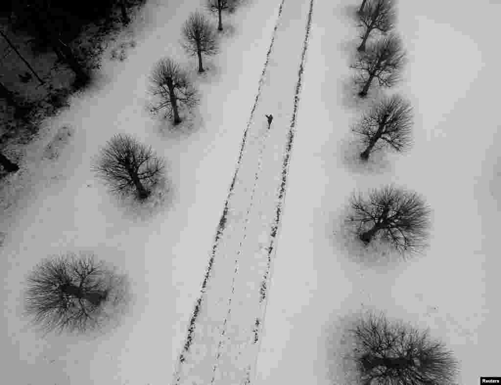 A person walks through the grounds of the Parish Church of Saint Mary and All Saints, in Whitmore, Staffordshire, Britain.