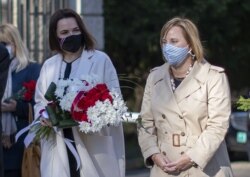 Belarusian opposition leader Svyatlana Tsikhanouskaya (left) and U.S. Ambassador to Belarus Julie Fisher take part at a ceremony to commemorate victims of the Chernobyl nuclear disaster in Vilnius, Lithuania on April 21.