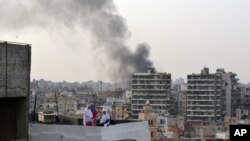 Smoke from burning tires rises over the Tripoli, Lebanon, skyline as people protest the killing Friday in Beirut of the country's intelligence chief, Brig. Gen. Wissam al-Hassan and at least seven others, October 20, 2012. 