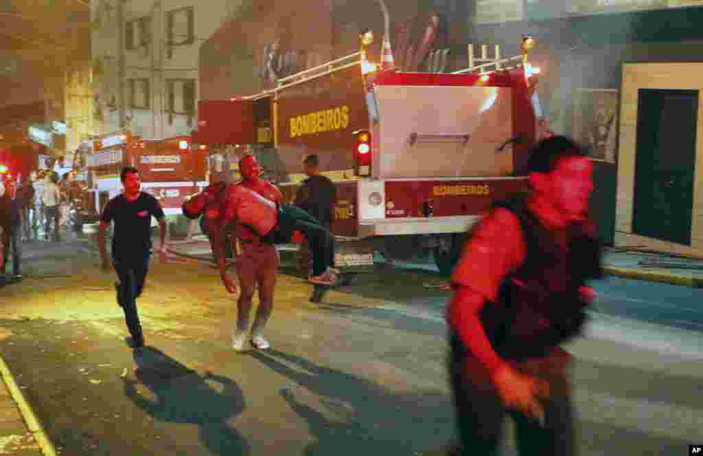 A man carries an injured victim of a fire at the Kiss club in Santa Maria city, Rio Grande do Sul state, Brazil, January 27, 2013.