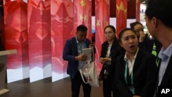 Attendees stand near a display of the Chinese flag during the China International Import Expo in Shanghai, Nov. 6, 2018.