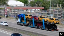 A truck carries new cars on the motorway leading to Paris, May 26, 2020 in Villacoublay, west of Paris.