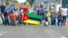 Alguns manifestantes ajoelhados gritam palavras de ordem durante manifestação no bairro Maxaquene, Maputo, Moçambique, 7 de novembro