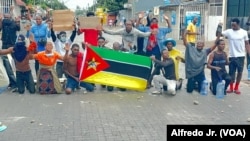 Alguns manifestantes ajoelhados gritam palavras de ordem durante manifestação no bairro Maxaquene, Maputo, Moçambique, 7 de novembro