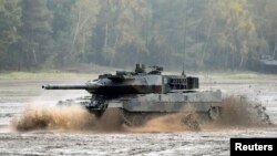 FILE - A Leopard 2 tank crosses a river during a German army, the Bundeswehr, training and information day in Munster, Germany, October 9, 2015.