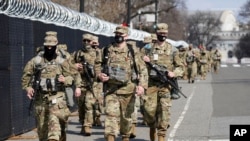 National Guard soldiers walk near the Capitol, March 4, 2021, on Capitol Hill in Washington.
