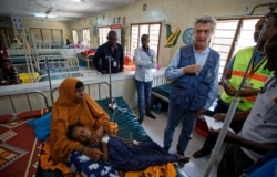 FILE - In this Tuesday, Dec. 19, 2017 file photo, U.N. refugee chief Filippo Grandi, center-right, visits a hospital as he tours Dadaab refugee camp, hosting over 230,000 inhabitants, in northern Kenya.