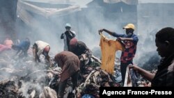 Traders scavenge clothes from debris burnt down by the fire in the early morning at Gikomba market, East Africa&#39;s largest second hand clothing market, in Nairobi, Kenya.