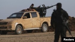 FILE - Rebel fighters are seen positioning themselves in Ghazila village in the southern countryside of Hasaka, Syria, Feb. 17, 2016.