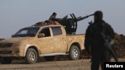 FILE - Rebel fighters are seen positioning themselves in Ghazila village in the southern countryside of Hasaka, Syria, Feb. 17, 2016.