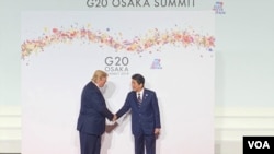 U.S. President Donald Trump, left, and Japanese Prime Minister Shinzo Abe shake hands at the Group of 20 summit in Osaka, Japan, June 28, 2019. (S. Herman/VOA/Radio pool)