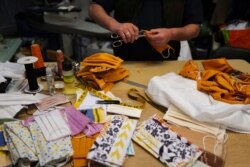 Tailor Yalcine of Boulard Retouche prepares face protective masks in cotton sewn in his shop at the Daguerre district in Paris, Sunday, May 3, 2020 as a nationwide confinement continue to counter the COVID-19.