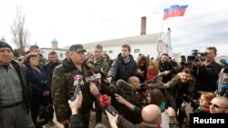 FILE - Colonel Sergei Storozhenko, commander of the military unit in the village of Perevalnoye, Crimea, talks to the media outside Simferopol, March 6, 2014, the day that Crimea's parliament voted to join Russia.