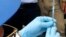 FILE - A health worker prepares an Ebola vaccine to administer to health workers during a vaccination campaign in Mbandaka, Congo,   May 21, 2018. 