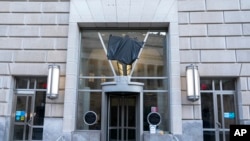 FILE - The door of the U.S. Agency for International Development, or USAID, is seen with the sign and logo removed from the wall outside of the agency's headquarters in Washington, Feb. 7, 2025.