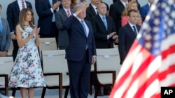 Le président des États-Unis Donald Trump, au milieu, la première dame des États-Unis, Melania Trump, à gauche, et le président français, Emmanuel Macron, à droite, saluent les militaires au le défilé traditionnel de la Bastille Day sur les Champs Elysées,