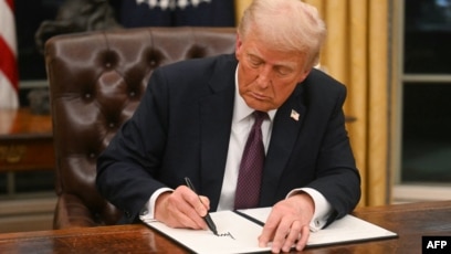 El presidente estadounidense Donald Trump firma una orden ejecutiva en la Oficina Oval de la Casa Blanca, en Washington, la noche del 20 de enero de 2025. AFP/Jim Watson