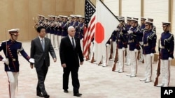 U.S. Vice President Mike Pence, third from left, and Japan's Prime Minister Shinzo Abe review an honor guard before their meeting at Abe's official residence in Tokyo Wednesday, Feb. 7, 2018. 