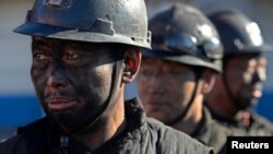 FILE - Miners wait in lines to shower during a break near a coal mine in Heshun county, Shanxi province, Dec. 5, 2014. 