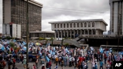 ARCHIVO: Manifestantes marchan frente al Palacio de Justicia, sede de la Corte Suprema, mientras conmemoran la Revolución de 1944 en la Ciudad de Guatemala, el 20 de octubre de 2023. Guatemala comenzó nuevamente el proceso de elección de jueces a los más altos tribunales. 