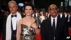 Les acteurs William Shimell et Juliette Binoche avec le réalisateur Abbas Kiarostami arrivant pour la projection du film "Copie Conforme", au 63ème festival international du film, à Cannes, en France, le 18 mai 2010. (AP Photo/Lionel Cironneau)