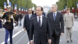 France's President Francois Hollande (C), Prime Minister Jean-Marc Ayrault (2ndR) and Junior Minister for Veterans Kader Arif (2dnL), walk on the Champs-Elysees avenue during the annual Bastille Day military parade in Paris, on July 14, 2012