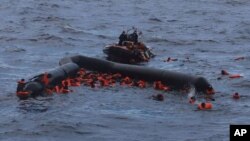 FILE - Refugees and migrants are rescued by members of the Spanish NGO Proactiva Open Arms, after leaving Libya trying to reach European soil aboard an overcrowded rubber boat in the Mediterranean sea, Nov. 11, 2020.