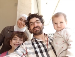 Maimouna al-Ammar, her husband and two daughters pose in a photo taken in 2018 in northern Syria after their displacement from eastern Ghouta near Damascus following a deal between the Syrian government and rebel groups. (Courtesy: Maimouna al-Ammar)
