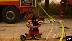 A firefighter from Slovakia cools himself down during a wildfire in Avgaria village on Evia island, about 184 kilometers (115 miles) north of Athens, Greece, Aug. 10, 2021. 