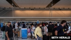 Travelers make their way to the gates at Detroit Metropolitan Wayne County Airport, in Detroit, Mich., June 12, 2021. Domestic travel is picking up across the United States as coronavirus disease case numbers drop.