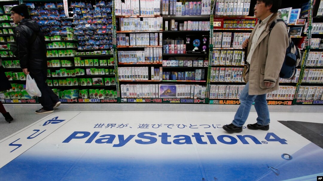 A shopper walks on the logo of Sony's PlayStation 4 at an electronics store in Tokyo, Dec. 25, 2014.