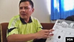 Ketua Ikatan Alumni Wyata Guna Bandung Suhendar, menunjukkan contoh surat suara braille untuk pemilu. (VOA/R. Teja Wulan)