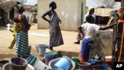 Ivorian women who have fled seen collecting water in Guiglo