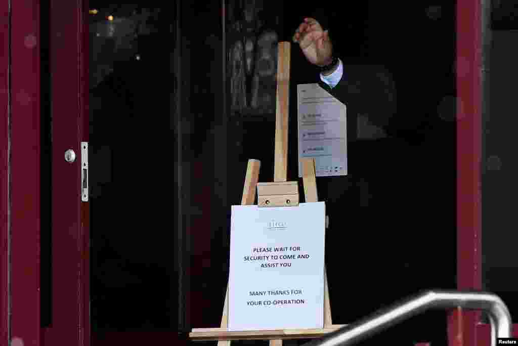 A hotel staff member gestures at the entrance of Crowne Plaza Dublin Airport Hotel, as Ireland introduces a hotel quarantine program for high-risk countries&#39; travelers, in Dublin, Ireland.