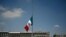 Vista de la bandera mexicana a media asta por las más de 60.000 muertes en el país por el COVID-19, en la plaza Zócalo de la Ciudad de México, el 2 de septiembre de 2020.