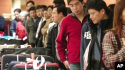 自上海飞抵台湾桃园国际机场的旅客在行李传送转盘处提领行李(2006年1月资料照片)