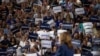 People raise signs in support of U.S. Vice President Kamala Harris as she speaks at a campaign event at West Allis High School in West Allis, Wisconsin, July 23, 2024. 