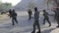 Afghan police officers run to the Kabul traffic police headquarters as it is attacked by insurgents in Kabul, January 21, 2013. 